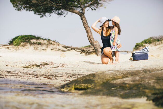 Menina e sua mãe têm um bom tempo à beira-mar