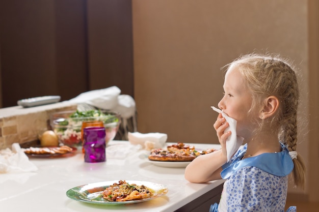 Foto menina educada comendo pizza caseira