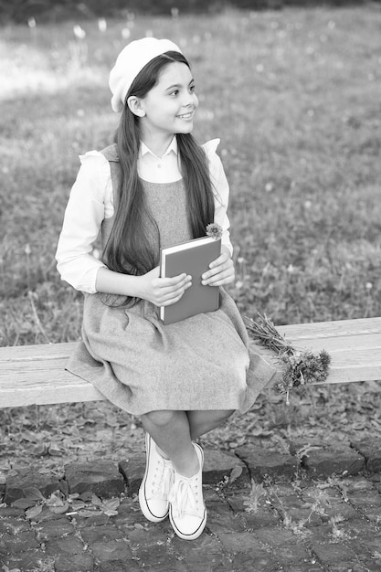 Menina elegante colegial com livro no conceito de literatura clássica do parque