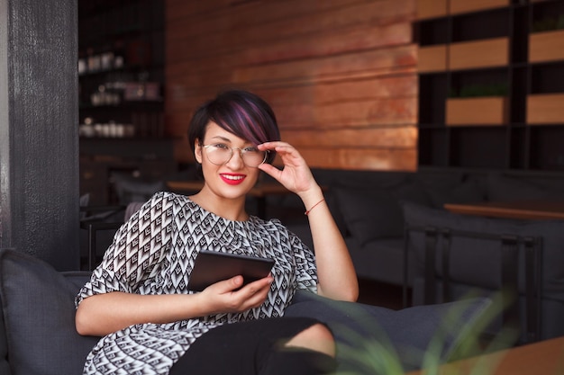 Menina elegante com tablet no café