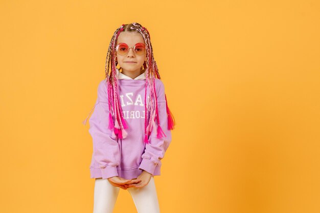 Foto menina elegante de óculos arredondados com dreadlocks rosa posando em um