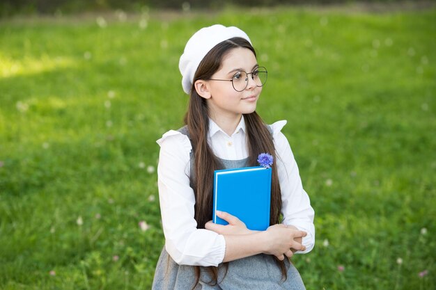 Menina elegante estudante estuda com livro no conceito de aluno da escola do parque