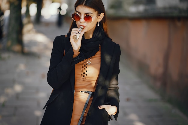 menina elegante, fumando um cigarro enquanto ela está andando pela cidade