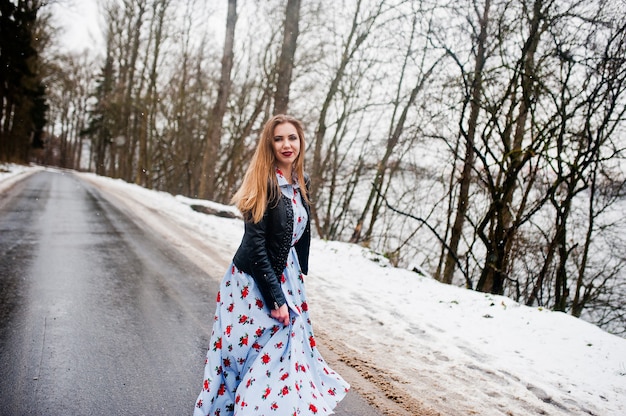 Menina elegante na jaqueta de couro no dia de inverno na estrada.