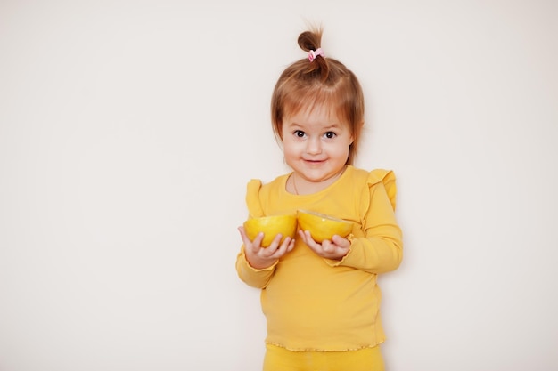 Menina em amarelo com limão, fundo isolado.