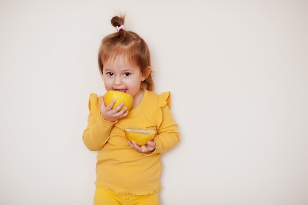 Menina em amarelo com limão, fundo isolado.
