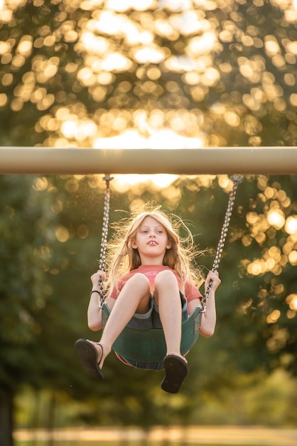 Menina em balanços à luz do sol