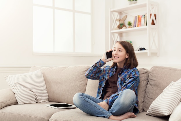 Foto menina em casa falando no celular