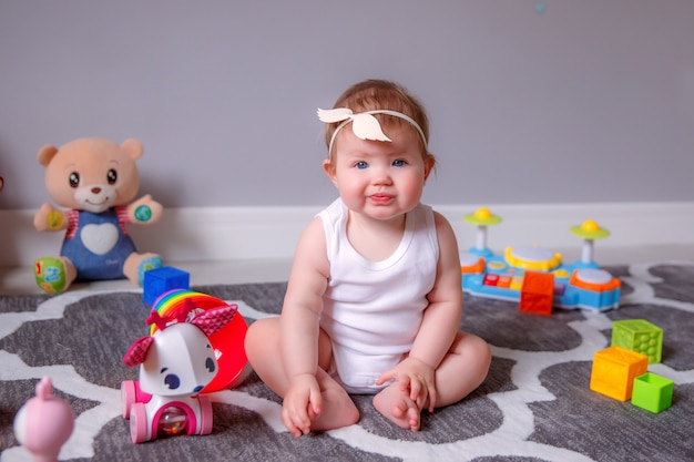 Menina em casa sentada no chão brincando com brinquedos