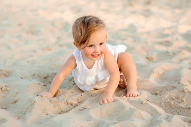 menina em roupas brancas, jogando em uma praia no verão