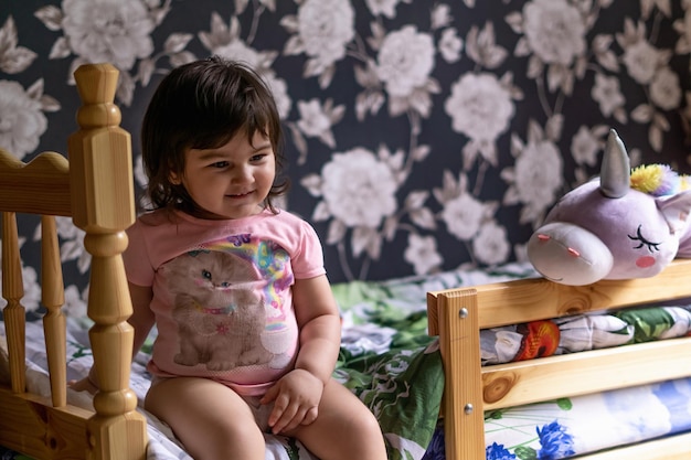 menina em seu quarto brincando com seus brinquedos e bichos de pelúcia