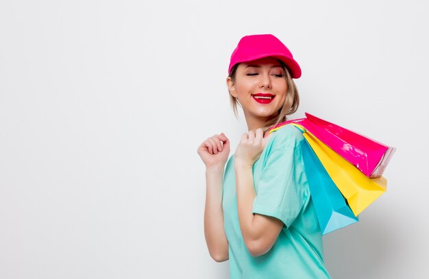 menina em t-shirt azul com sacos de compras