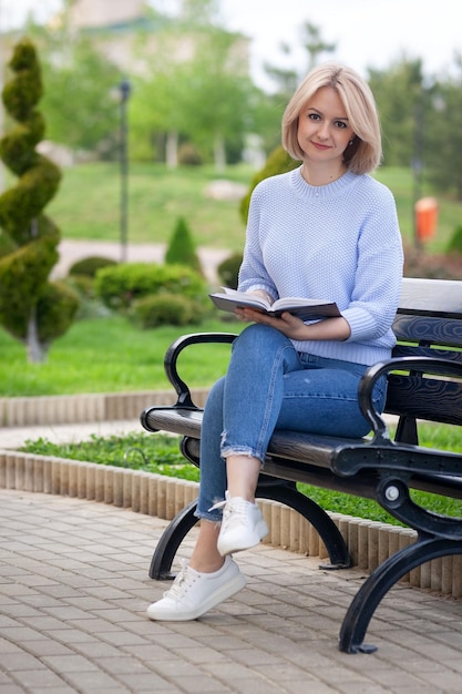 Menina em um café na rua lendo um livro