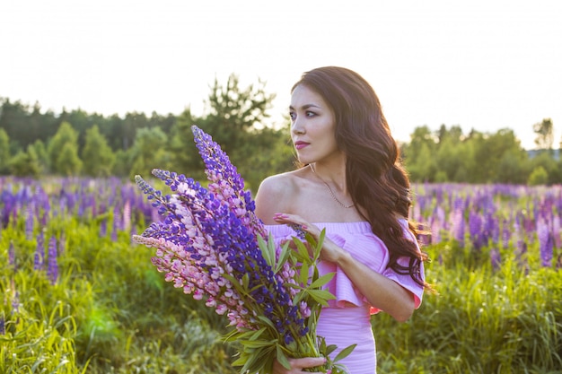 Menina em um campo de flores de tremoço