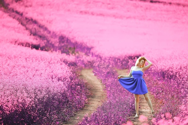 menina em um campo de flores lilás em cores de lavanda, paisagem violeta e rosa, feliz e harmonia