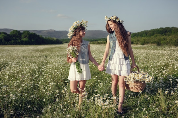 Menina em um campo de flores margarida. meninas em uma coroa de margaridas brancas, o conceito e a ideia de uma infância feliz