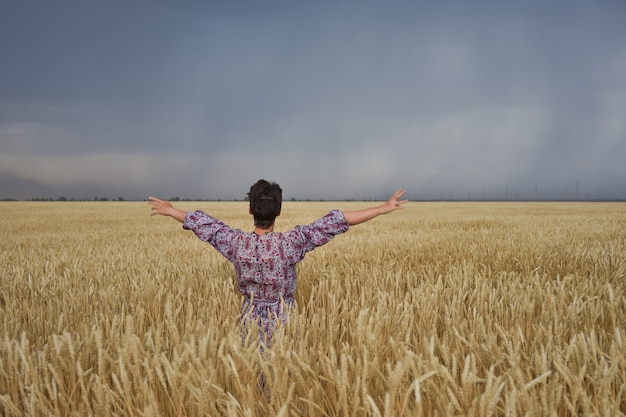 Menina em um campo de trigo antes de uma tempestade
