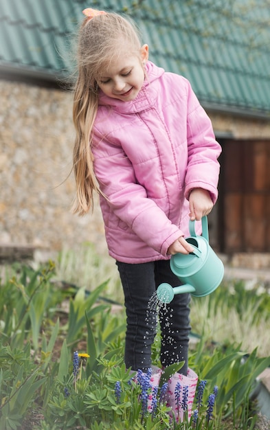 Menina em um jardim com regador verde