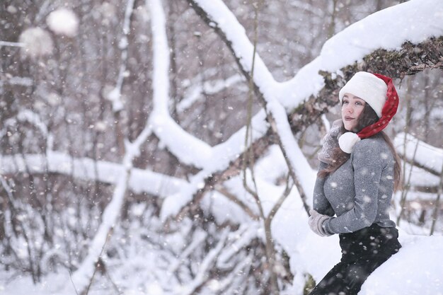 Menina em um parque de inverno à tarde na neve