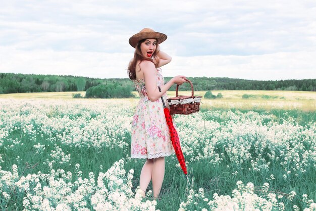 Menina em um prado de verão com uma flor branca em um dia nublado