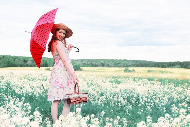 Menina em um prado de verão com uma flor branca em um dia nublado