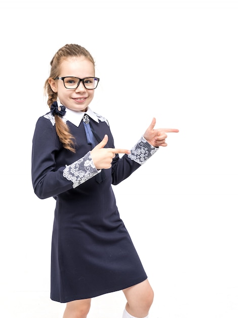 Foto menina em um uniforme azul da escola emocionalmente posando em um fundo branco