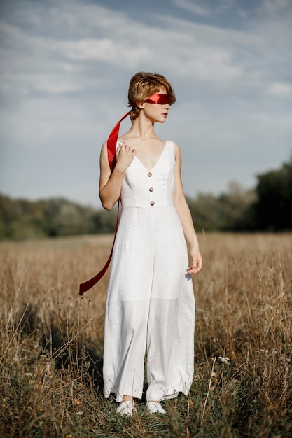 Menina em um vestido branco com uma fita vermelha