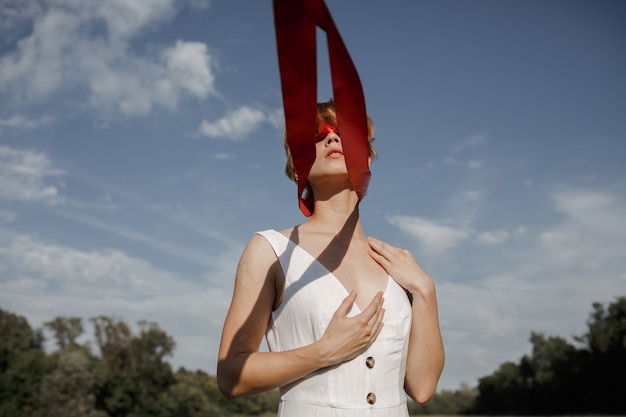 Menina em um vestido branco com uma fita vermelha