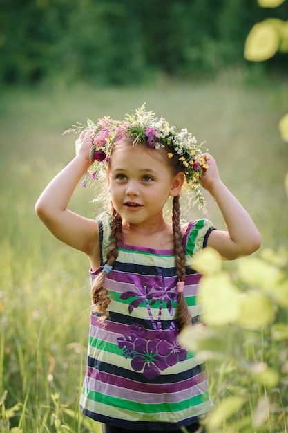 menina em uma coroa de flores silvestres no verão