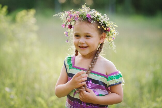 menina em uma coroa de flores silvestres no verão