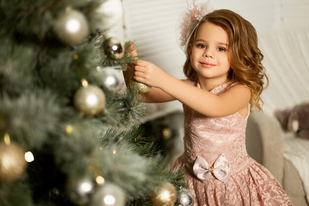 Menina em uma sala com árvore de Natal e enfeites