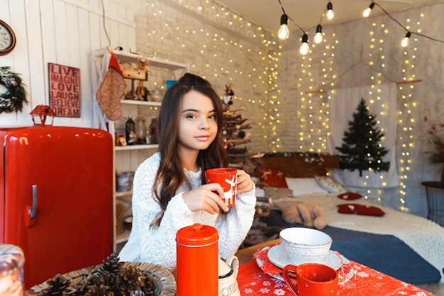 Menina em uma sala com decorações de natal