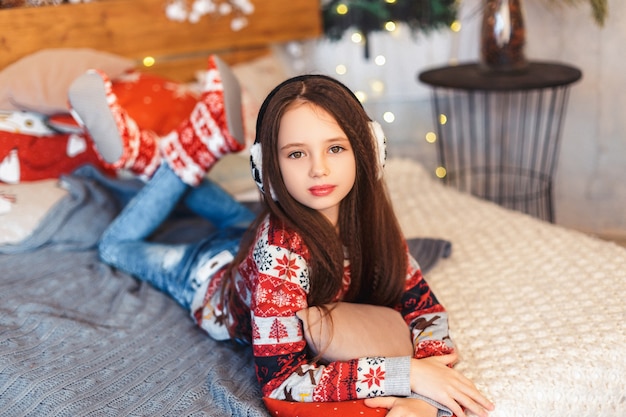 Menina em uma sala com decorações de natal