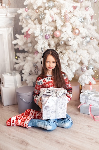 Menina em uma sala com decorações de Natal