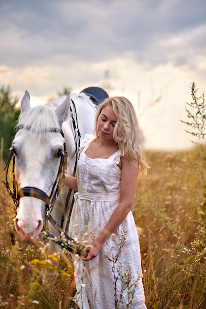 Menina, em, vestido branco, segurando, um, cavalo, em, a, campo