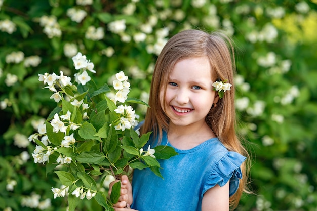 Menina encantadora cheirando flores de jasmim