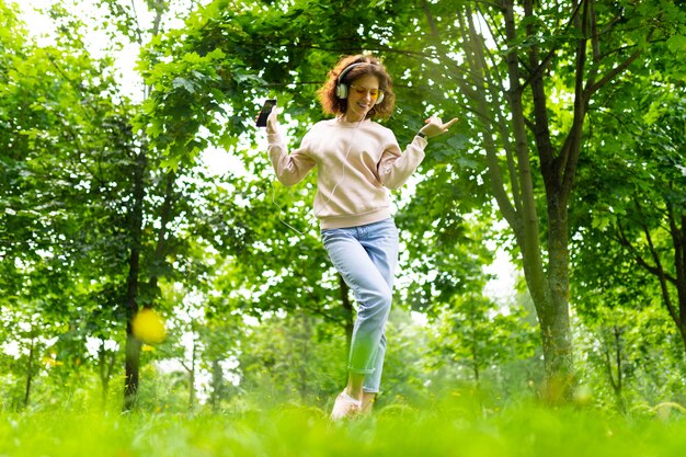 menina encantadora medita a música em um parque verde verão