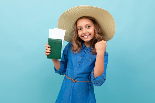 Menina encantadora mostra um passaporte com ingressos e se alegra