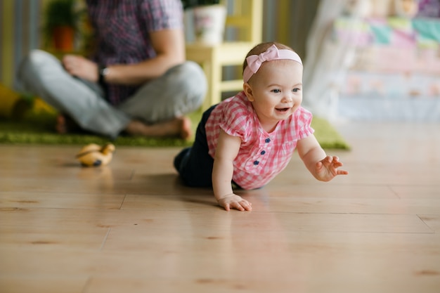 Menina engatinhando engraçado. Conceito de família feliz