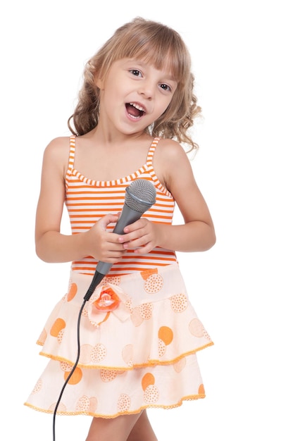 Menina engraçada cantando com um microfone isolado em fundo branco