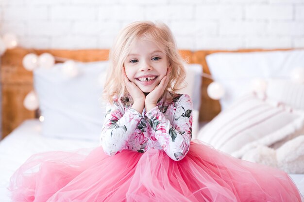 Menina engraçada com sorriso dentário usando um vestido rosa da moda