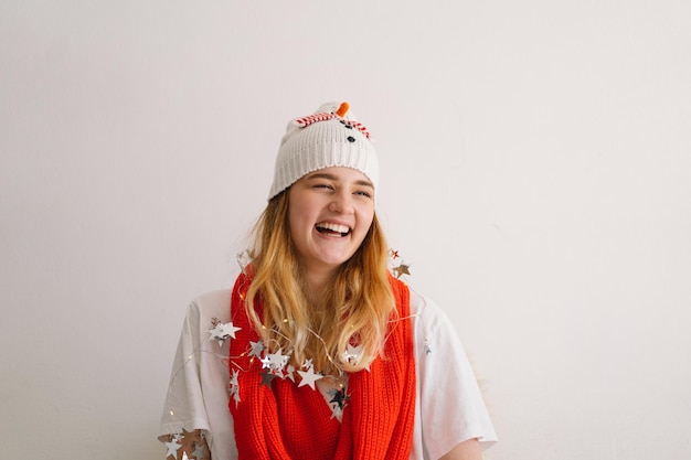 Menina engraçada com um chapéu de Natal com um boneco de neve e um lenço vermelho Ano Novo e conceito de Natal