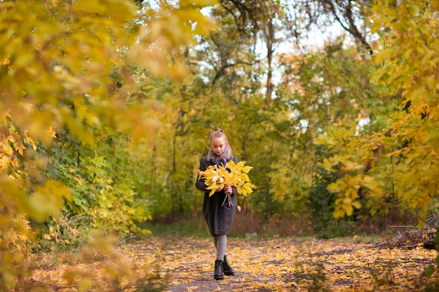 Menina entra no parque outono folhagem amarela brilhante