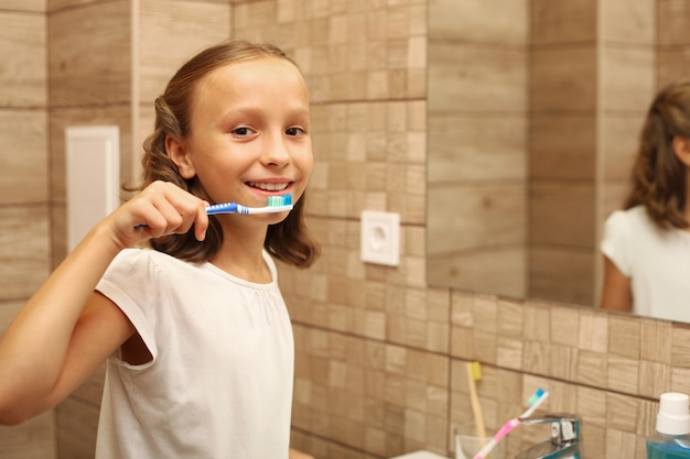 Menina escovando os dentes, cuidados dentários para crianças