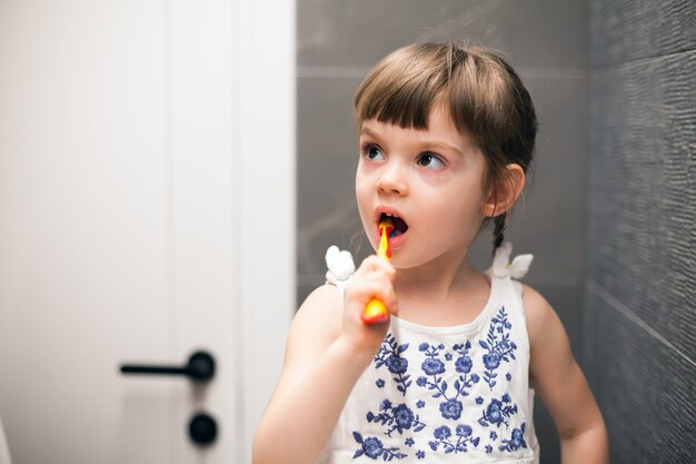 Menina escovando os dentes em um banheiro