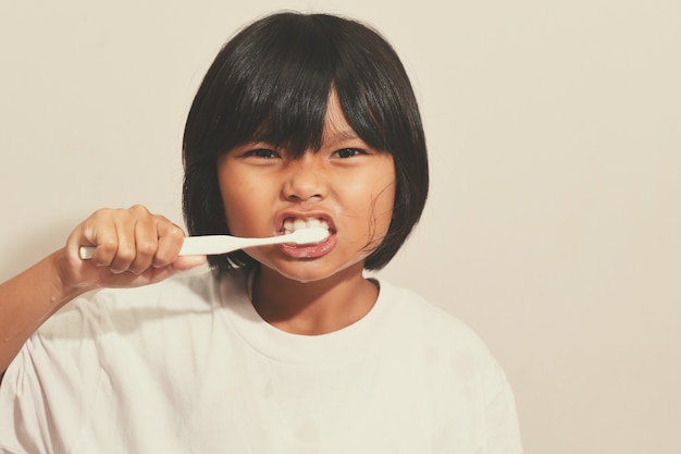 Menina escovando os dentes no banheiro