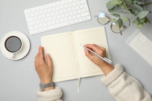 Menina escreve no caderno, vista superior. Conceito de negócio ou blogueiro