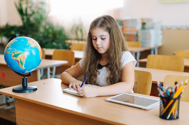 Menina escrevendo na aula