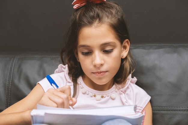 Menina escrevendo no caderno