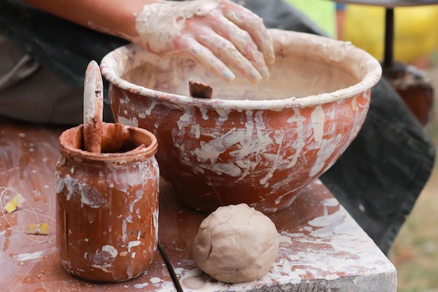 Menina esculpindo pratos de argila com as mãos